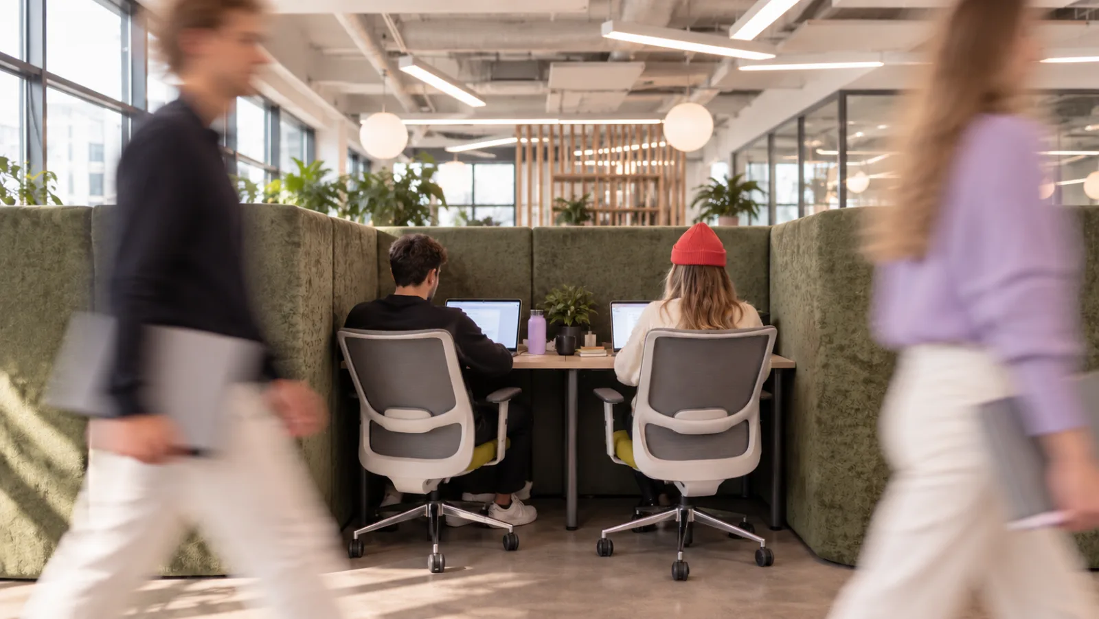 Two colleagues working at laptops in an open office